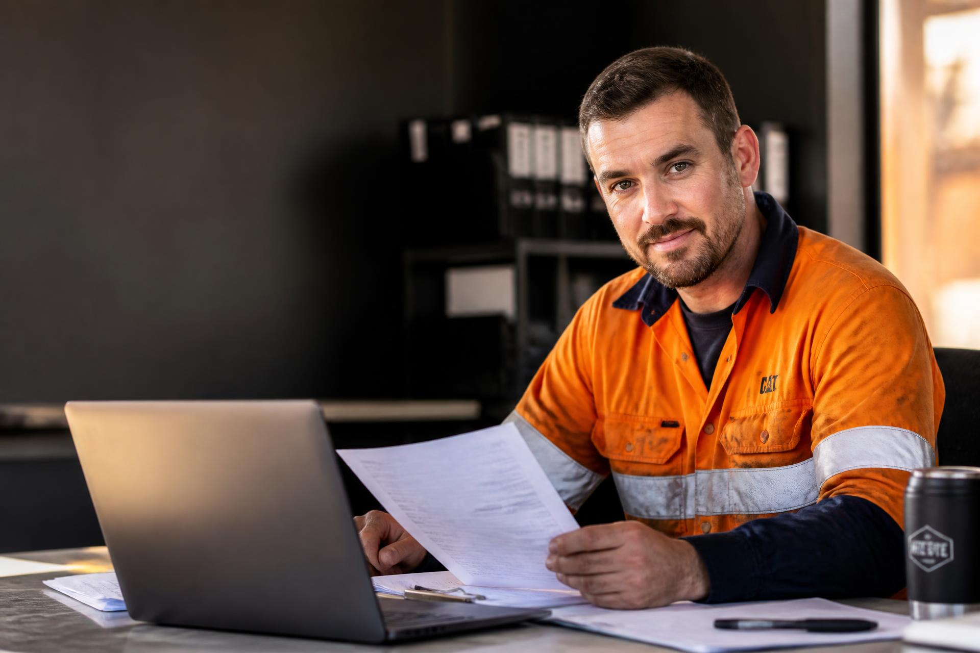Australian mining worker in high-vis reviewing tax paperwork at a laptop